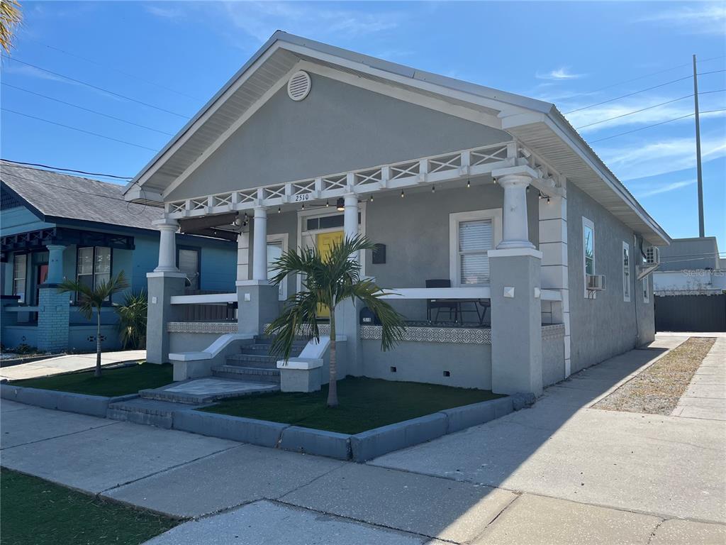 A gray bungalow with a front porch, white columns, and a yellow front door — 2510 W MAIN STREET, TAMPA, FL