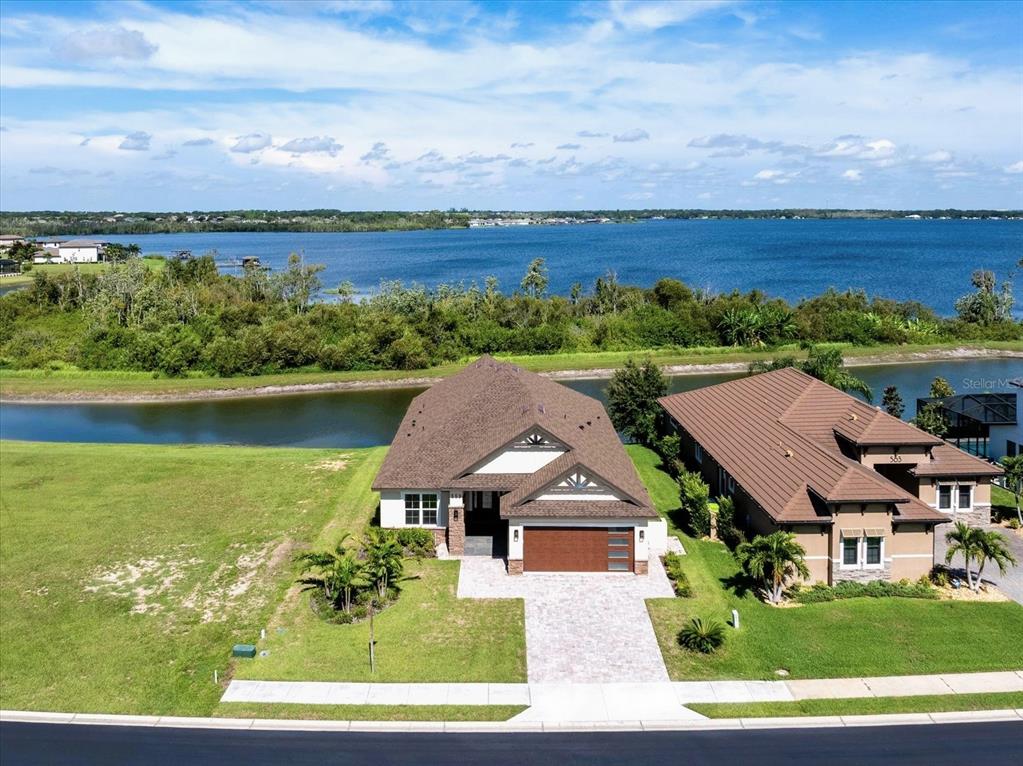 An aerial view shows a single-story house with a brown roof and paved driveway — 559 WATERFERN TRAIL DRIVE, AUBURNDALE, FL