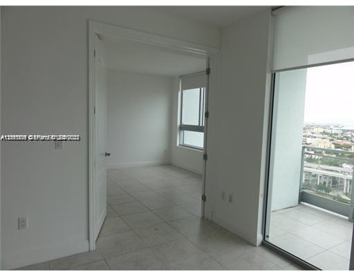 An interior view showing a tiled room with a doorway leading to another space and balcony — 90 SW 3rd St # 2907, Miami FL 33130, MIAMI, FL