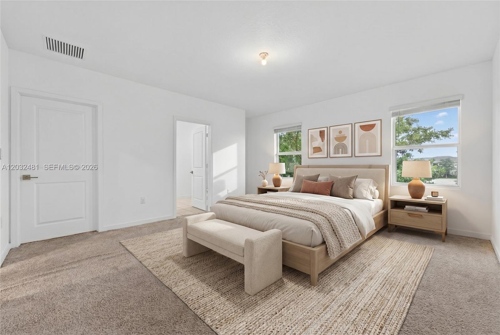 A bedroom features a bed with a neutral-toned headboard, two nightstands, and a textured rug — 1780 SE 9th Ave, Homestead FL 33034, HOMESTEAD, FL