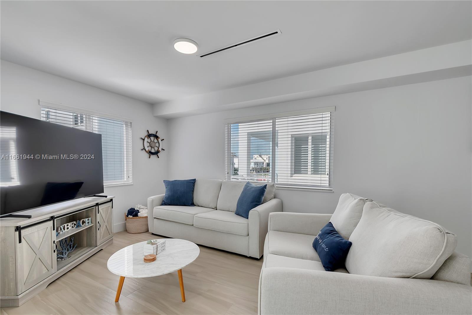 A living room features two light-colored sofas, a marble coffee table, and a television console — 94825 Overseas Highway # 144, Key Largo FL 33037, KEY LARGO, FL