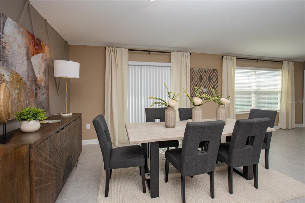 A dining room features a light wood table, dark gray chairs, and a wooden sideboard — 5228 WORCHESTER DRIVE, KISSIMMEE, FL