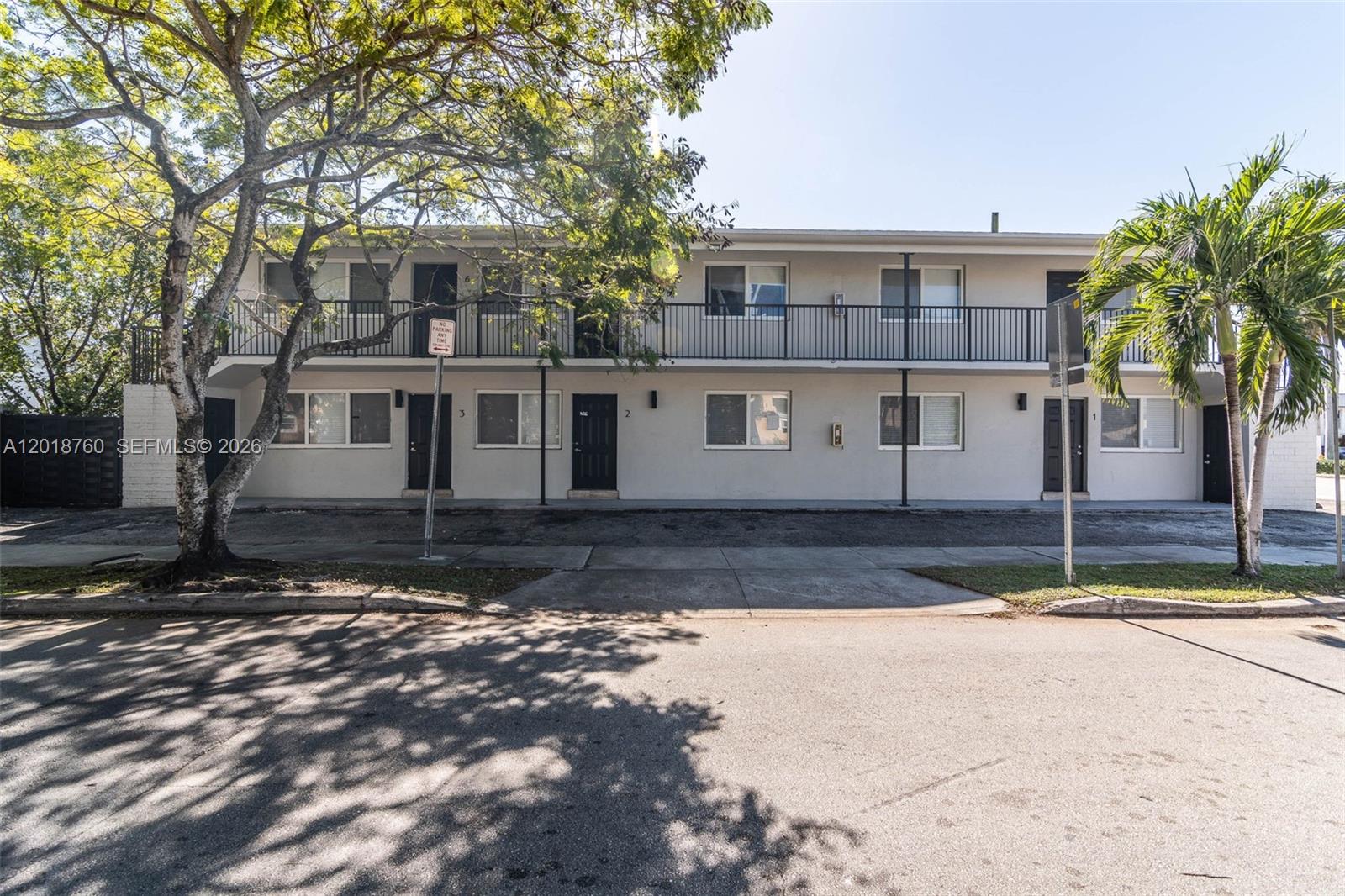 A two-story apartment building features a balcony, black doors, and a paved parking area — 2190 SW 14th Ter, Miami FL 33145, MIAMI, FL