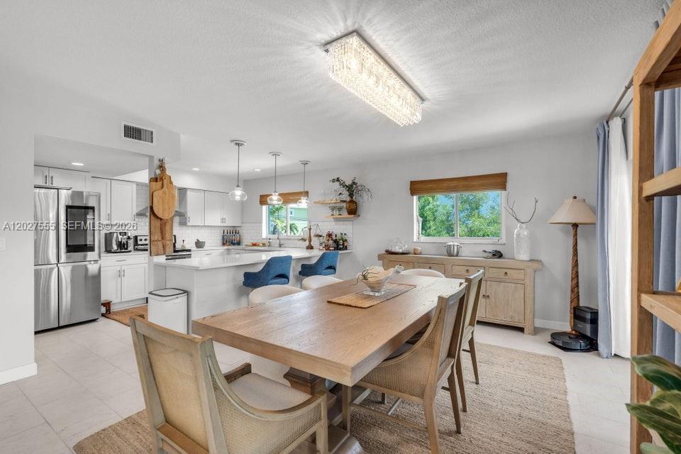 A dining area with a wooden table and chairs sits adjacent to a modern kitchen — KEY LARGO, FL