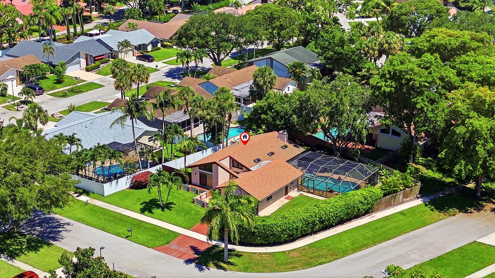 An aerial view shows a suburban house with a brown roof and a screened pool — 21540 Kapok Circle, Boca Raton FL 33433, BOCA RATON, FL