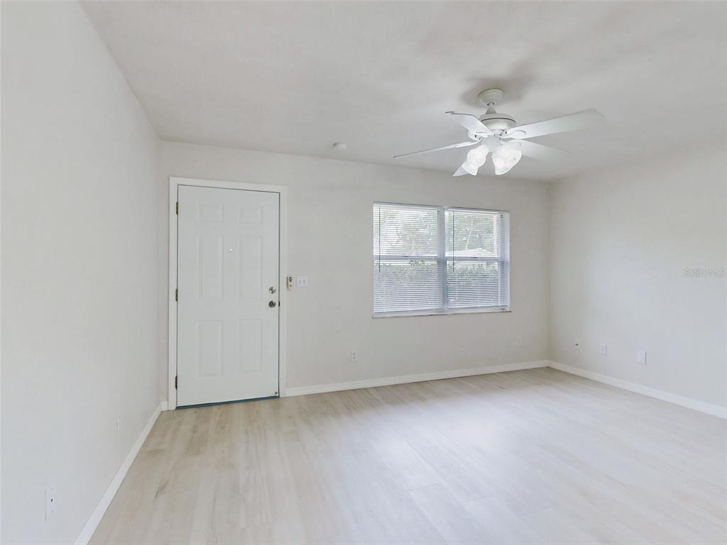 A living room features a beige sofa, wooden coffee table, and light-colored flooring — 111 VALENCIA DRIVE, EDGEWATER, FL
