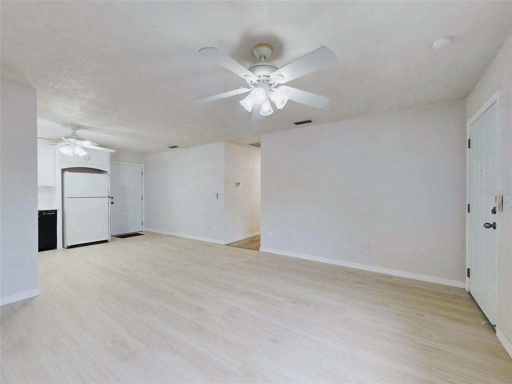 A bright living room features a fireplace, ceiling fan, and an adjacent open kitchen — 111 VALENCIA DRIVE, EDGEWATER, FL