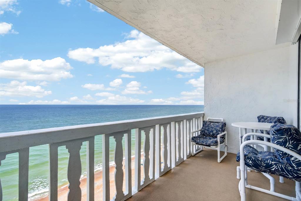 A balcony with white railings overlooks the ocean under a blue sky with clouds — 1575 OCEAN SHORE BOULEVARD UNIT 805, ORMOND BEACH, FL