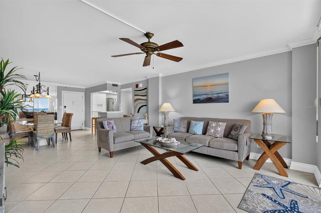 A living room with tile floors, a ceiling fan, and gray sofas near a dining area — 1575 OCEAN SHORE BOULEVARD UNIT 805, ORMOND BEACH, FL