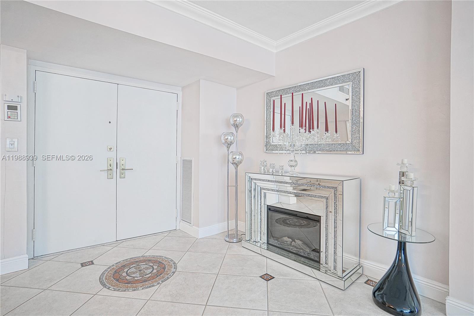 A foyer features a mirrored fireplace, a matching wall mirror, and light-colored tile flooring — 9 Island Ave # 2410, Miami Beach FL 33139, MIAMI BEACH, FL