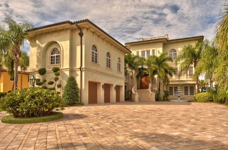 A large, multi-story Mediterranean-style house with a three-car garage and a paved circular driveway — 220 GULF BOULEVARD UNIT 8, BELLEAIR BEACH, FL