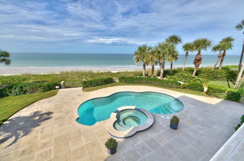 An elevated view of a backyard swimming pool and hot tub overlooking a sandy beach — 220 GULF BOULEVARD UNIT 8, BELLEAIR BEACH, FL