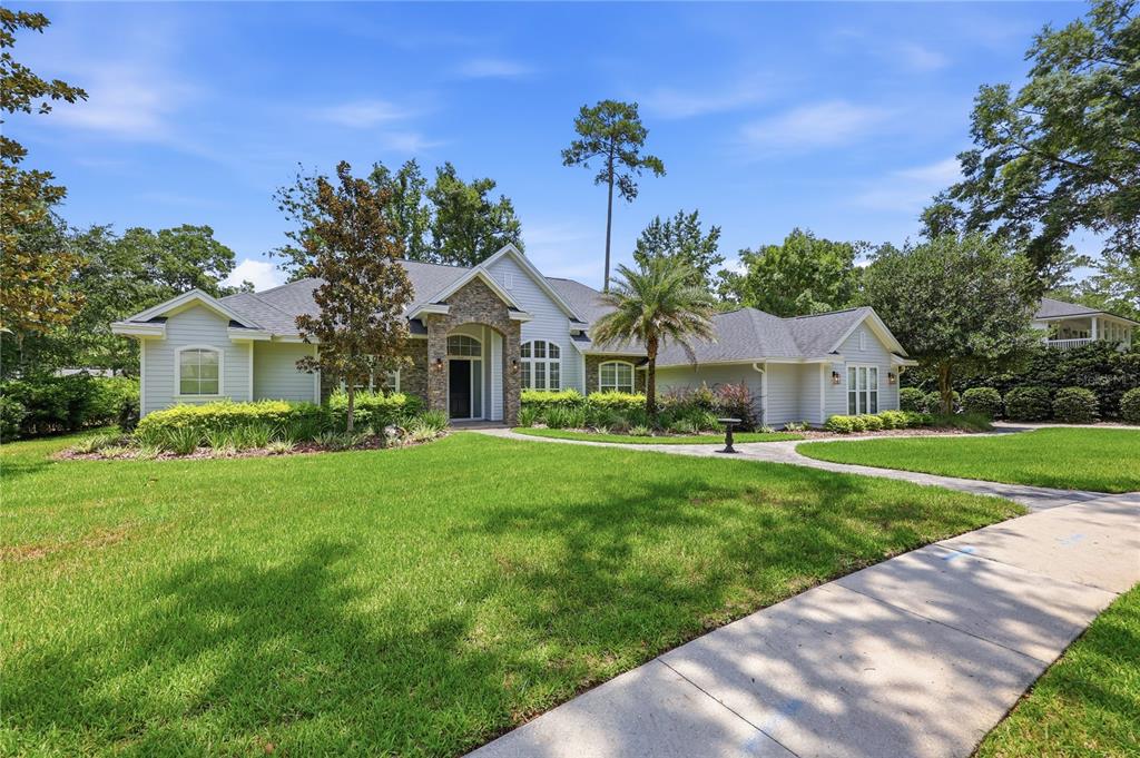 A single-story house with light siding, a stone entryway, and a manicured lawn — 5117 NW 55TH STREET, GAINESVILLE, FL