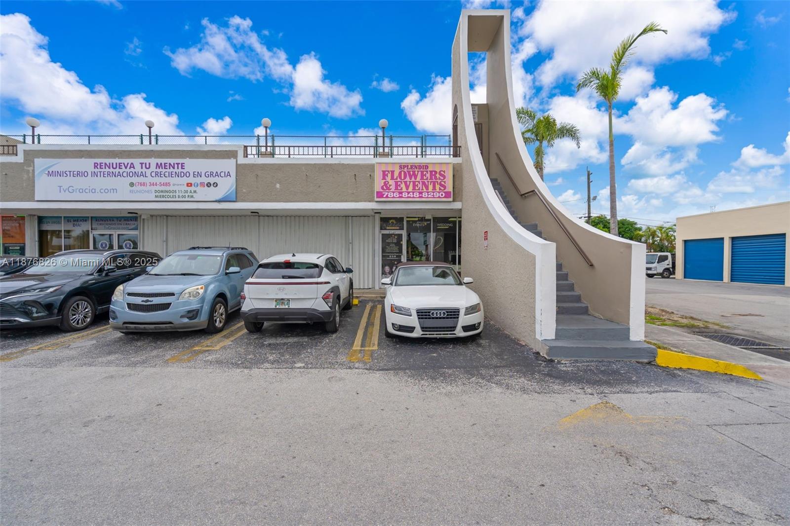A commercial building exterior features a staircase, parking spaces, and signage for two businesses — 7147 SW 8th St, Miami FL 33144, MIAMI, FL