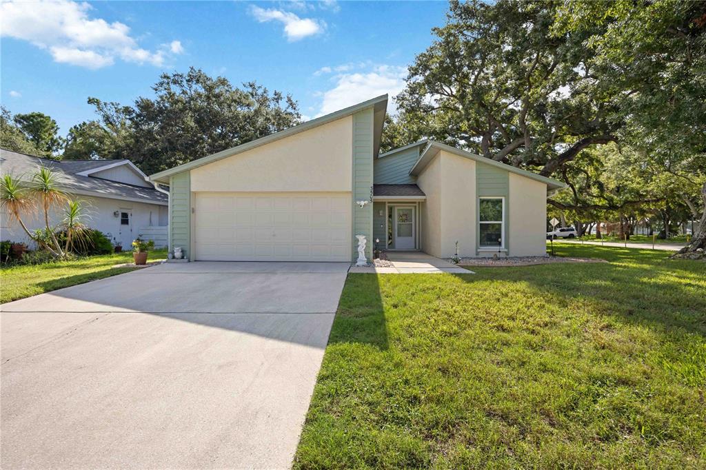 A single-story house with a two-car garage, light-colored stucco walls, and green vertical trim — 3505 45TH STREET W, BRADENTON, FL