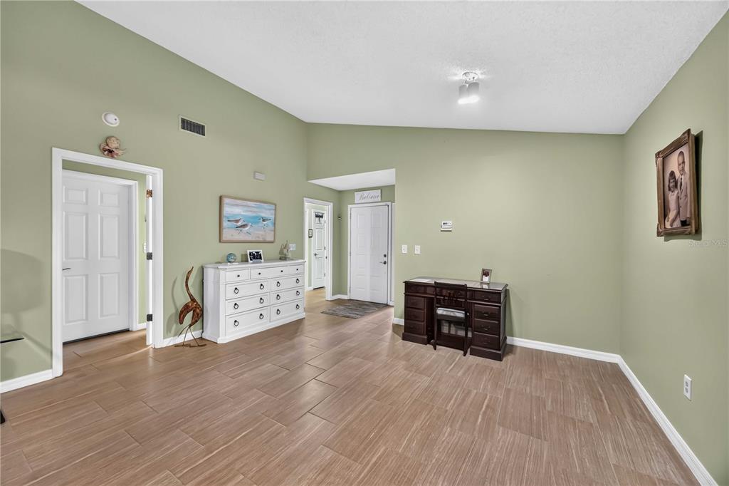 A spacious room with light green walls, wood-look tile flooring, a white dresser, and desk — 3505 45TH STREET W, BRADENTON, FL