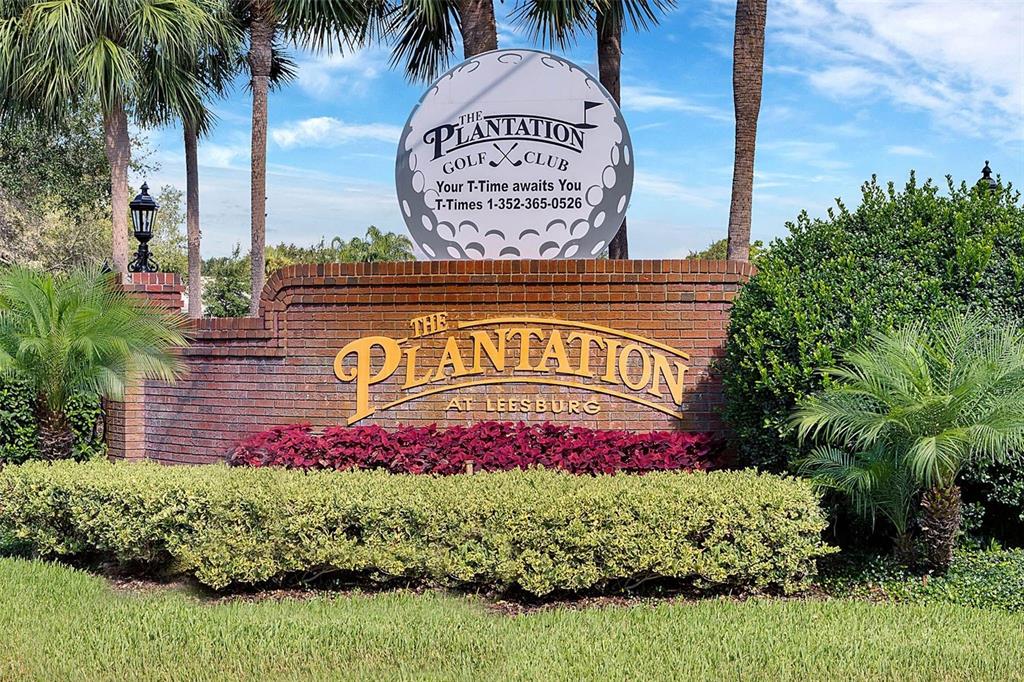 A brick entrance sign for The Plantation at Leesburg features a large golf ball sculpture — 4721 TARA VIEW ROAD, LEESBURG, FL