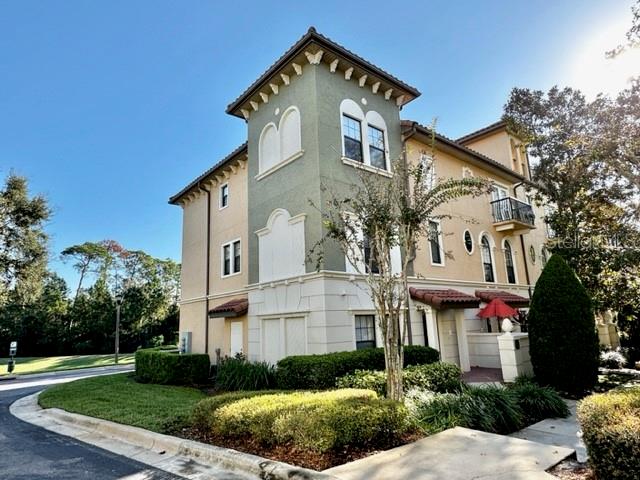 A three-story tan and green building features a corner tower and a small balcony — 4232 MESSINA DRIVE, LAKE MARY, FL