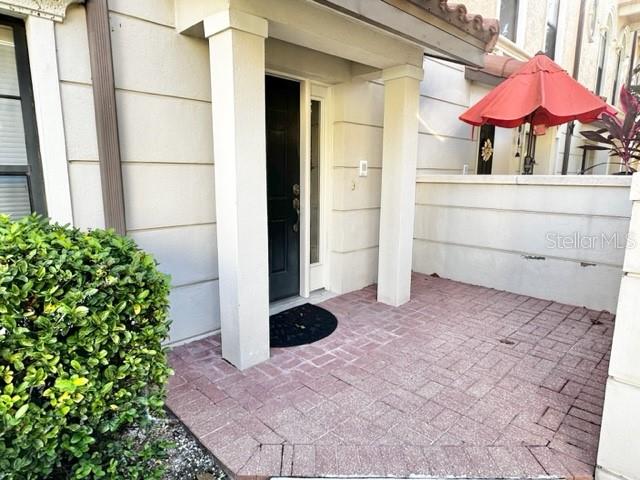 A brick patio leads to a black front door under a covered entryway — 4232 MESSINA DRIVE, LAKE MARY, FL