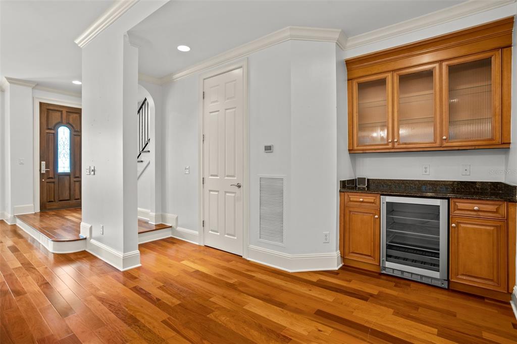 A room with hardwood floors, a wooden wet bar, and a doorway leading to stairs — 1136 S PENNSYLVANIA AVENUE, WINTER PARK, FL