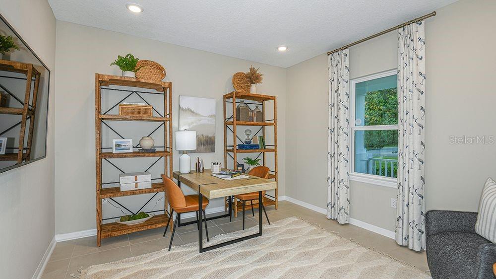 A home office features two wooden bookshelves, a desk with two chairs, and patterned curtains — 4 ARMENIA COURT, PALM COAST, FL