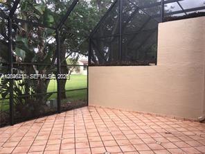 A screened-in patio features light-colored tile flooring and a view of a grassy lawn — 3933 Adra Ave # 47, Doral FL 33178, DORAL, FL
