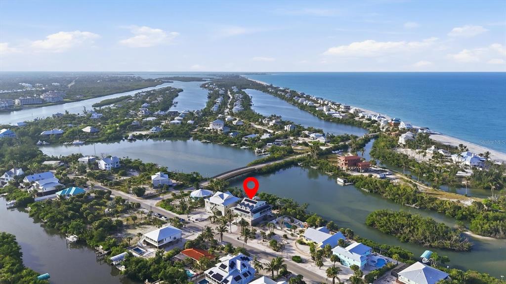 An aerial view shows a coastal house with a red location pin near water — 81 N GULF BOULEVARD, PLACIDA, FL