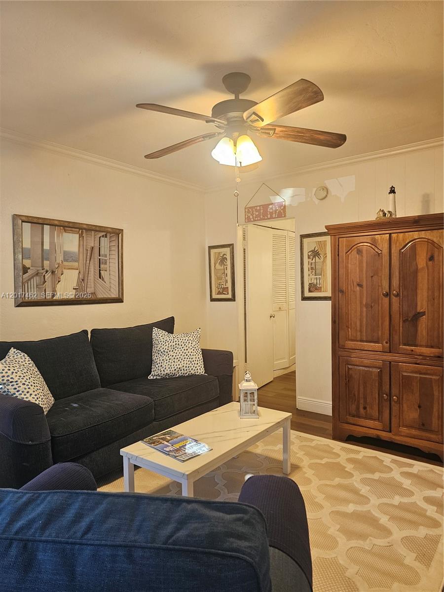 A living room features a dark sofa, a wooden armoire, and a ceiling fan — 325 Fernwood Rd # 10, Key Biscayne FL 33149, KEY BISCAYNE, FL
