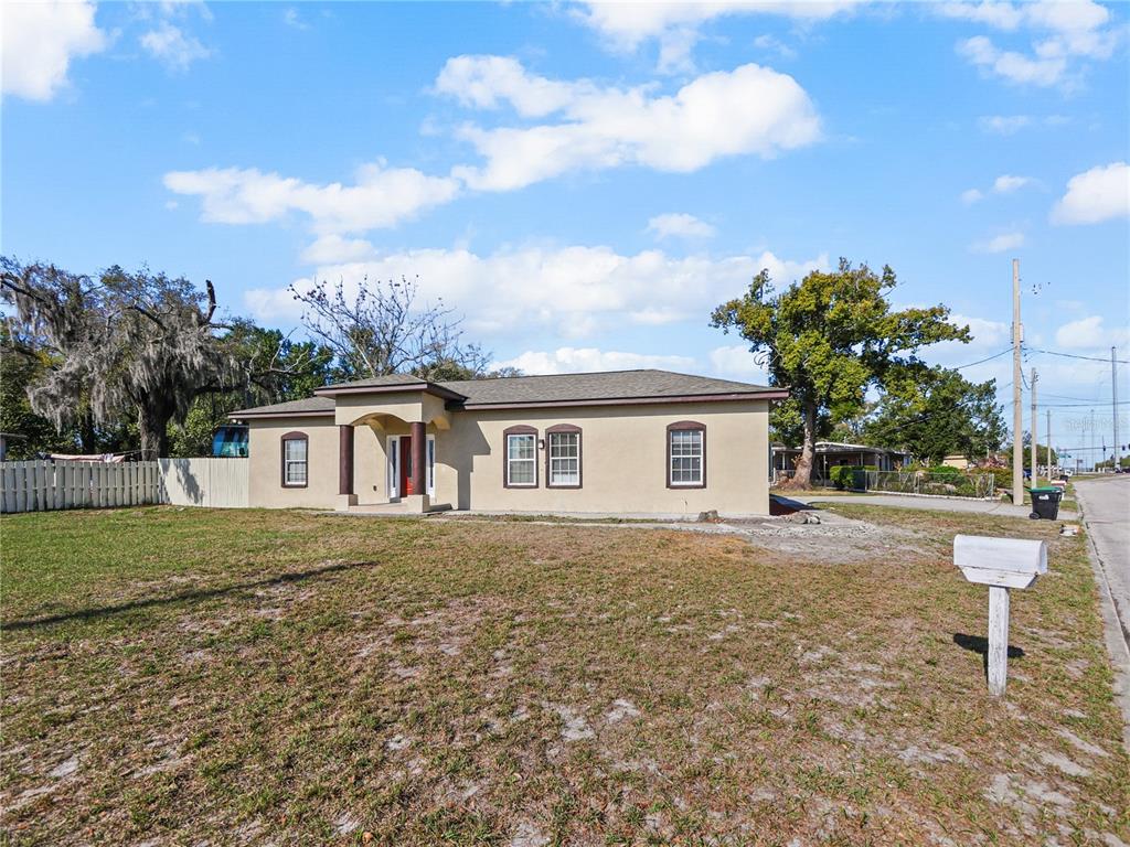 A single-story tan house with a covered entryway stands on a grassy lot — 4901 BALBOA DRIVE, ORLANDO, FL