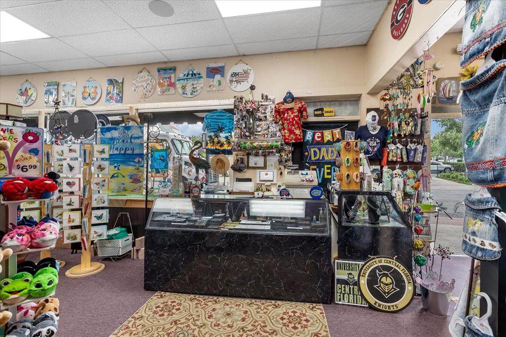 A retail shop interior features a black marble service counter and various gift store merchandise — 317 N DONNELLY, MOUNT DORA, FL