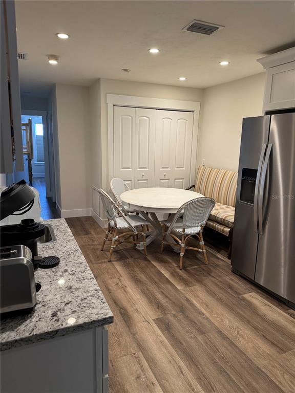A kitchen features a round dining table, a bench, two chairs, and stainless steel appliances — 30 SE VALARE LANE UNIT 102C, CRYSTAL RIVER, FL