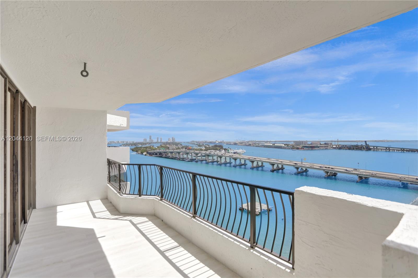 A balcony with a metal railing overlooks a bridge spanning a large body of water — 555 NE 15th St # 20I, Miami FL 33132, MIAMI, FL