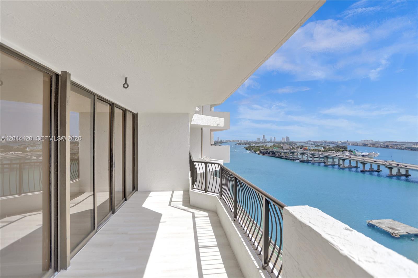 A balcony with a metal railing overlooks a bridge spanning a body of water — 555 NE 15th St # 20I, Miami FL 33132, MIAMI, FL