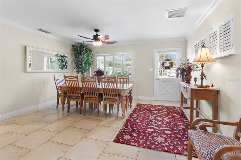 A dining room features tile floors, a wooden table with six chairs, and a rug — 3326 BOUGAINVILLEA STREET, SARASOTA, FL
