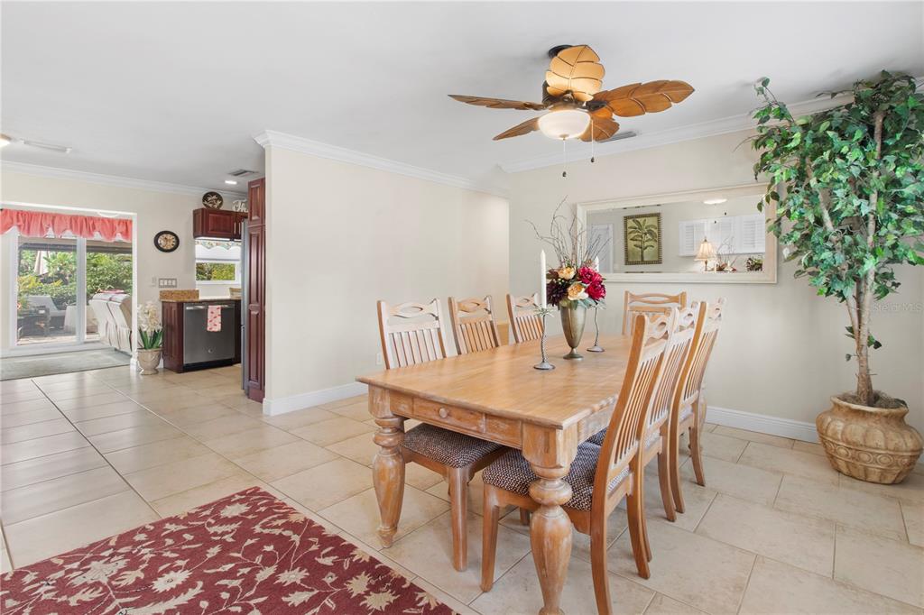 A dining room features a wooden table with chairs, tile flooring, and a ceiling fan — 3326 BOUGAINVILLEA STREET, SARASOTA, FL