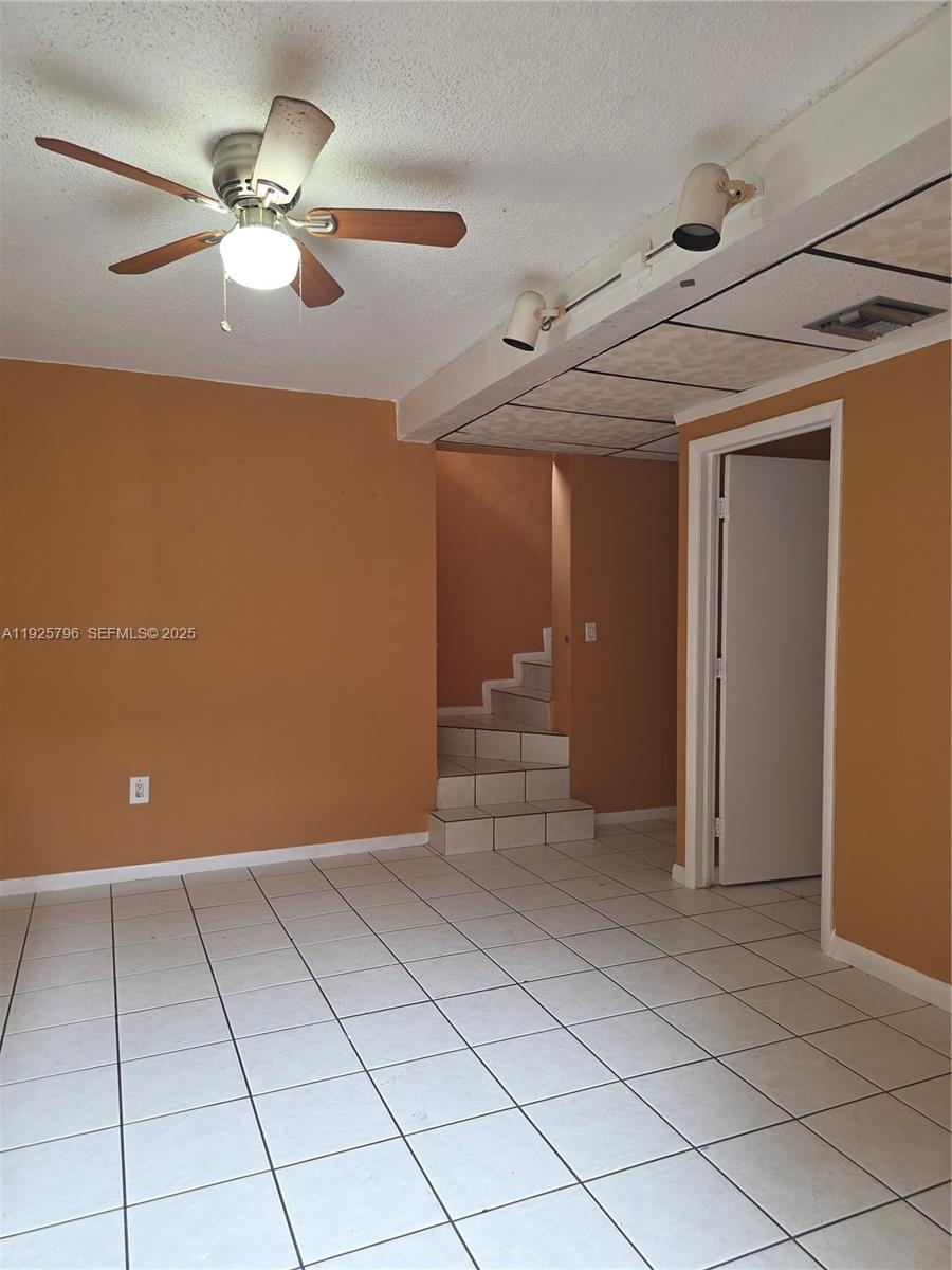 This room features orange walls, white tile flooring, a ceiling fan, and tiled stairs — 250 NW 63rd Ct # 2, Miami FL 33126, MIAMI, FL