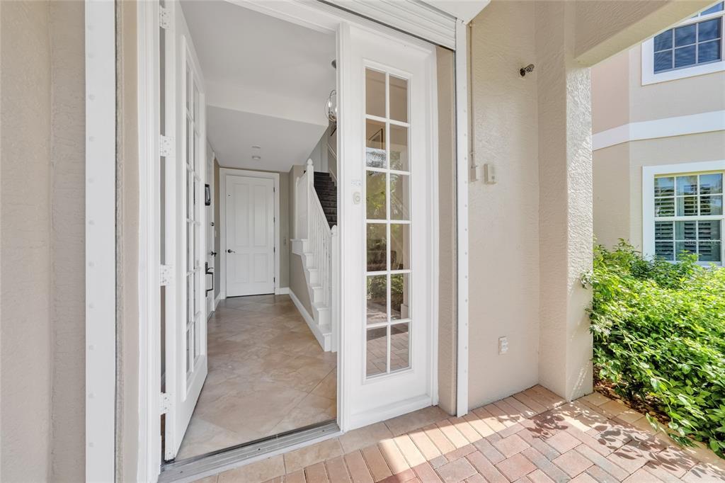 A palm tree stands in front of a house with a tan exterior and white trim — 196 TARPON COVE BOULEVARD UNIT 722, PUNTA GORDA, FL
