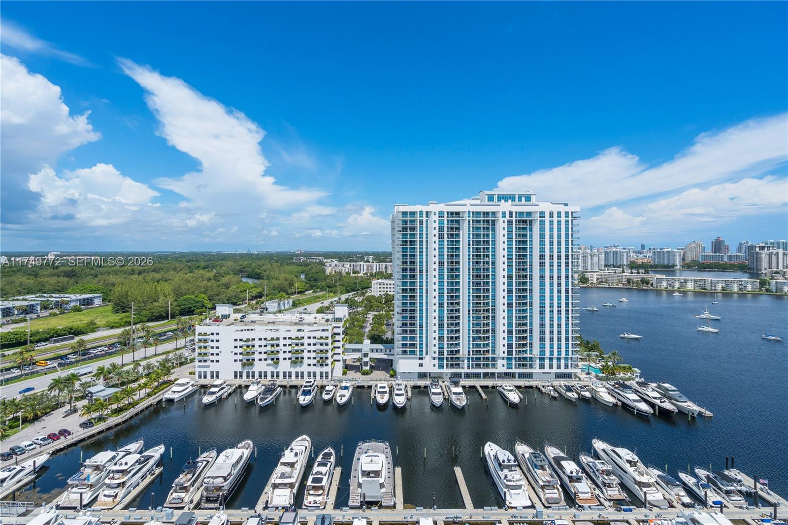 An aerial view shows a high-rise residential building, a parking structure, and a marina — 17111 Biscayne Blvd # 2001, North Miami Beach FL 33160, NORTH MIAMI BEACH, FL