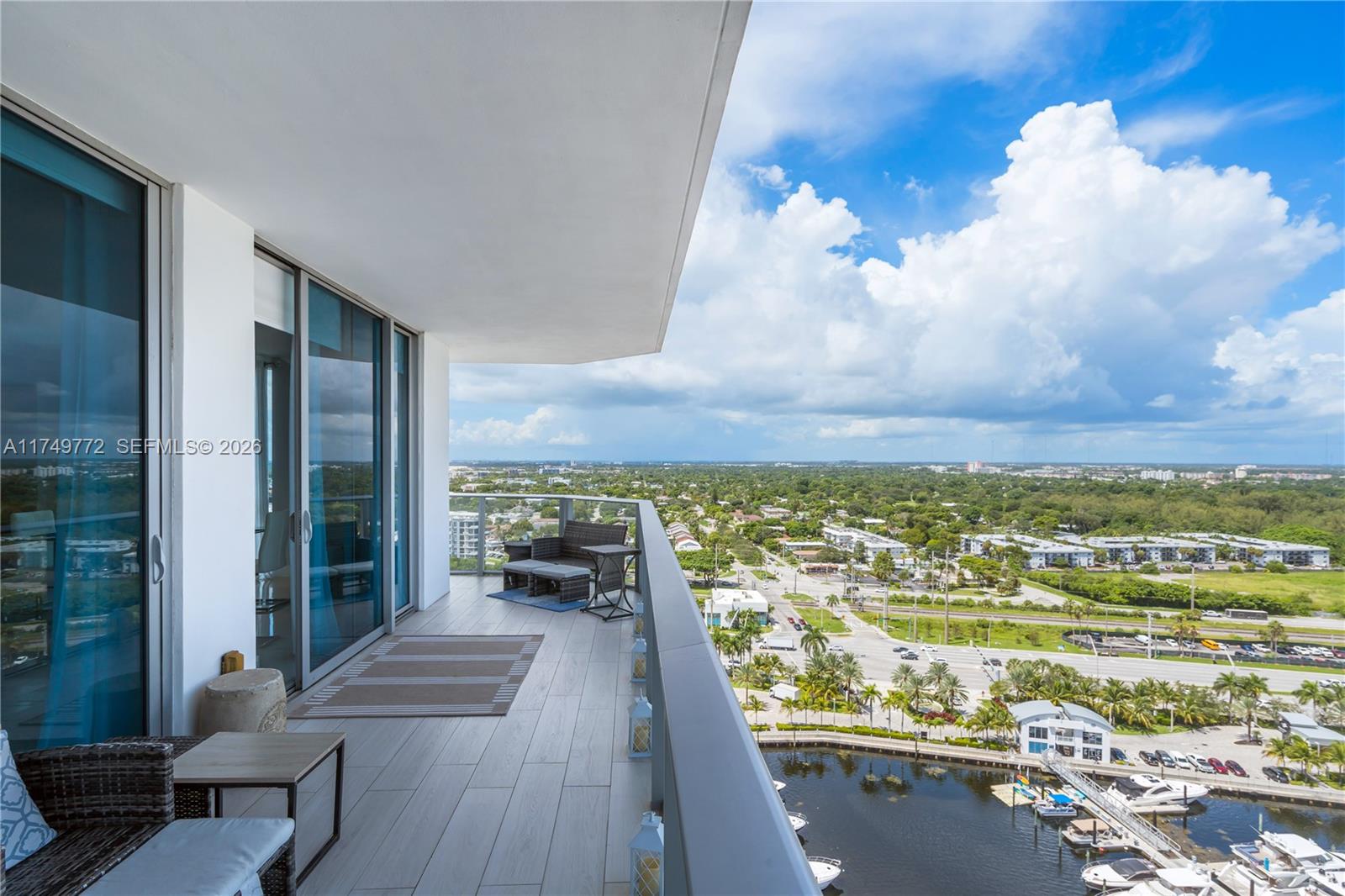 A high-rise balcony features tile flooring, outdoor furniture, and a view of a marina — 17111 Biscayne Blvd # 2001, North Miami Beach FL 33160, NORTH MIAMI BEACH, FL