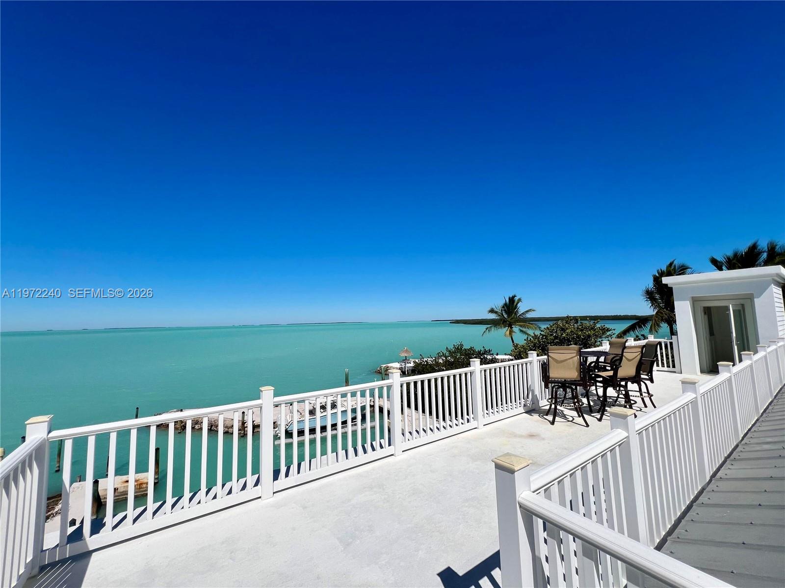 A white balcony with railings overlooks a turquoise ocean under a clear blue sky — 20 Avacado St, Islamorada FL 33036, ISLAMORADA, FL