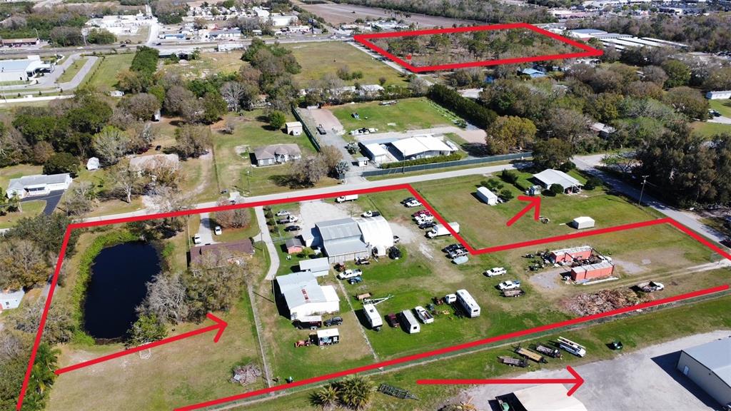 An aerial view shows a large, multi-parcel property with several buildings, a pond, and vehicles — 2601 11TH AVENUE SE, RUSKIN, FL