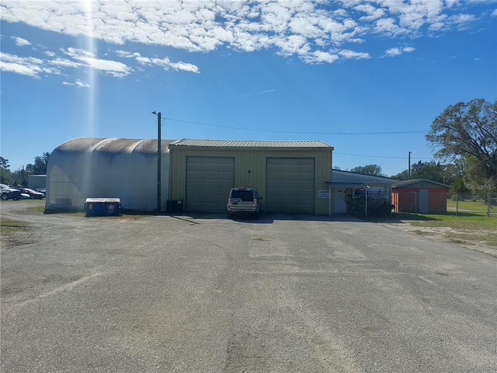 A metal warehouse building with two roll-up doors sits on a large gravel lot — 2601 11TH AVENUE SE, RUSKIN, FL