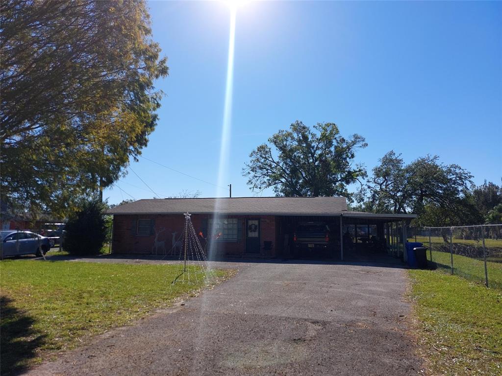 A single-story brick house with a carport and a paved driveway under a clear sky — 2601 11TH AVENUE SE, RUSKIN, FL