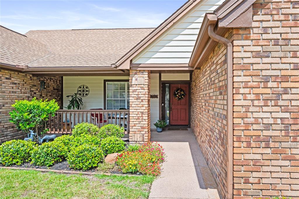 A brick house exterior features a red front door, a small porch, and landscaped bushes — 638 WHITE RIVER DRIVE, ORLANDO, FL