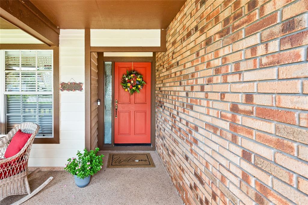 A front porch features a red door, brick wall, and a rocking chair — 638 WHITE RIVER DRIVE, ORLANDO, FL