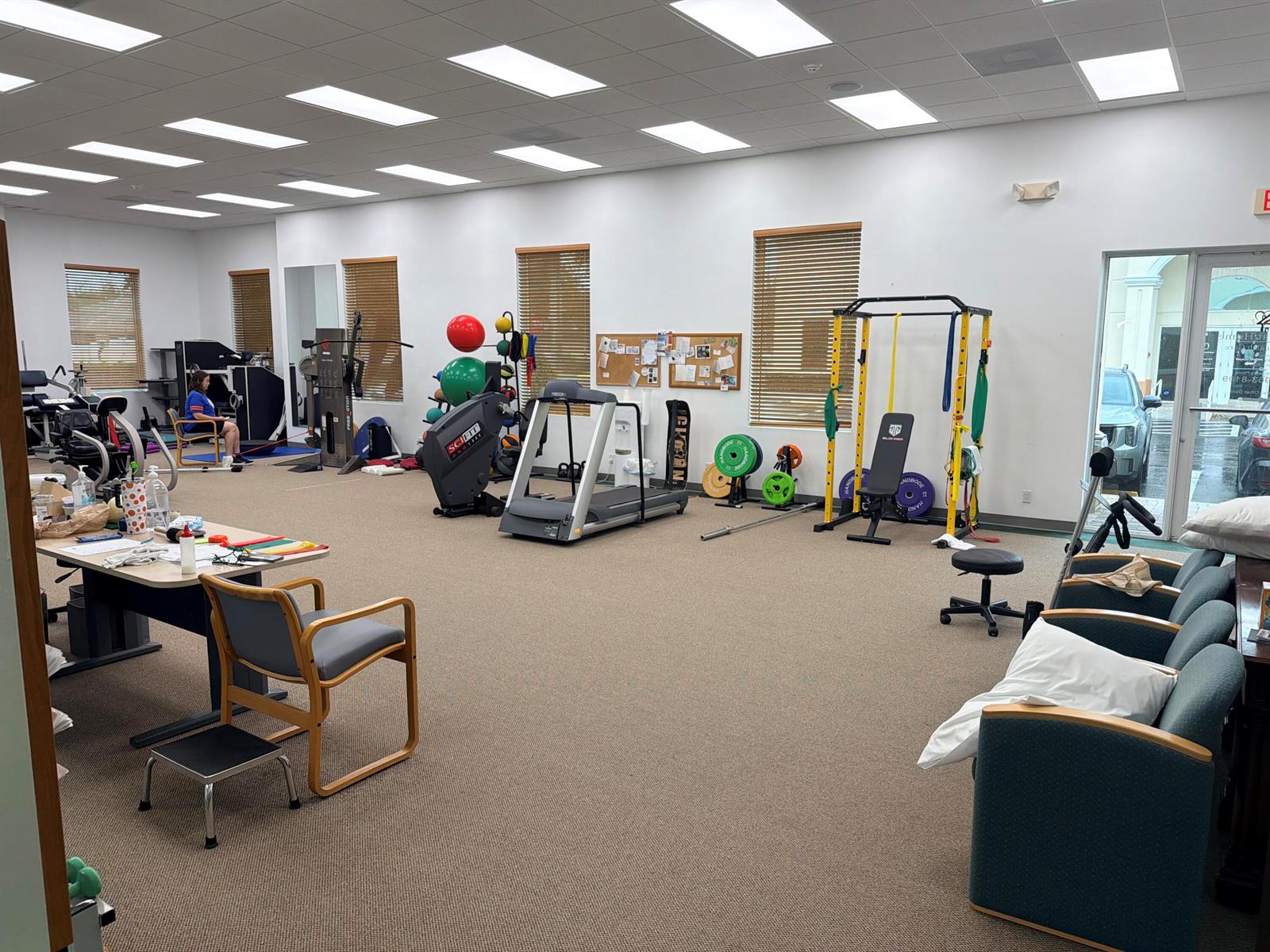 A physical therapy clinic features exercise equipment, a desk, seating, and carpeted flooring — 5055 S Congress Avenue # 304, Atlantis FL 33461, ATLANTIS, FL