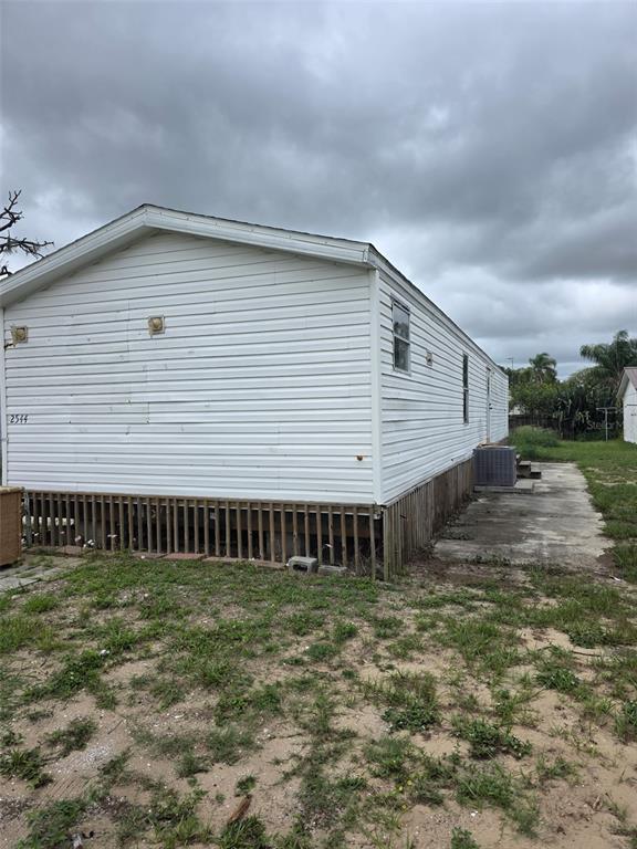 A white mobile home with horizontal siding sits on a lot with a concrete pad — 2544 EL DORADO AVENUE, AVON PARK, FL