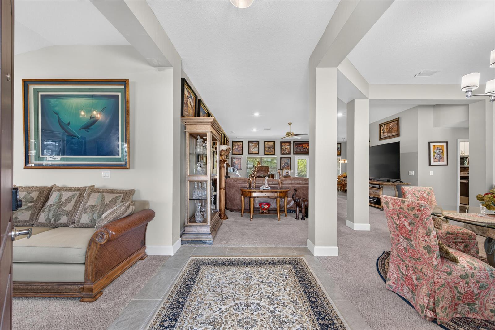 A view from an entryway looking into a living room with carpeted floors and furniture — 8659 Waterstone Boulevard, Fort Pierce FL 34951, FORT PIERCE, FL