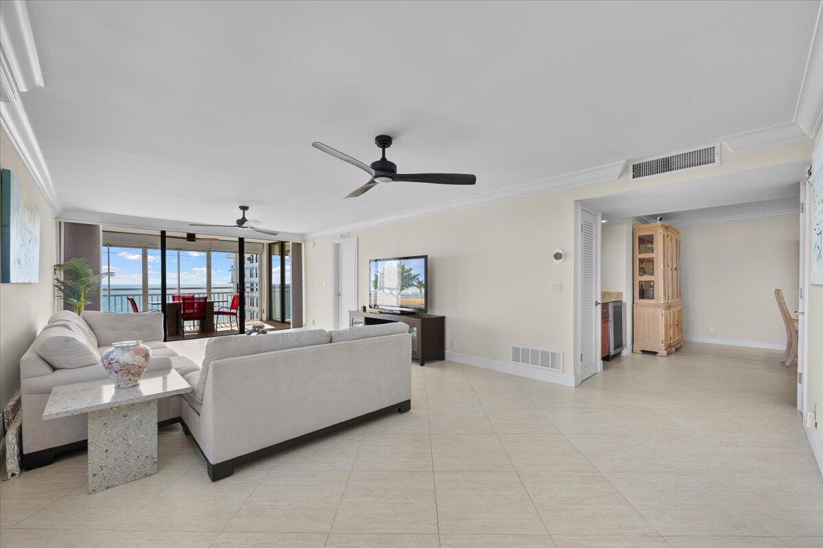 A living room with light tile floors, a sectional sofa, and a view of the ocean — 911 Ocean Drive # 506, North Palm Beach FL 33408, NORTH PALM BEACH, FL