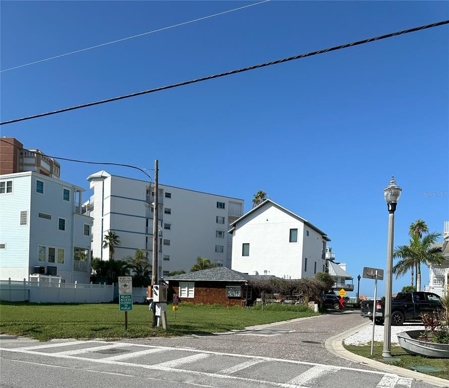 A street view shows a grassy lot, a small brown building, and nearby multi-story structures — 181st AVE W, REDINGTON SHORES, FL